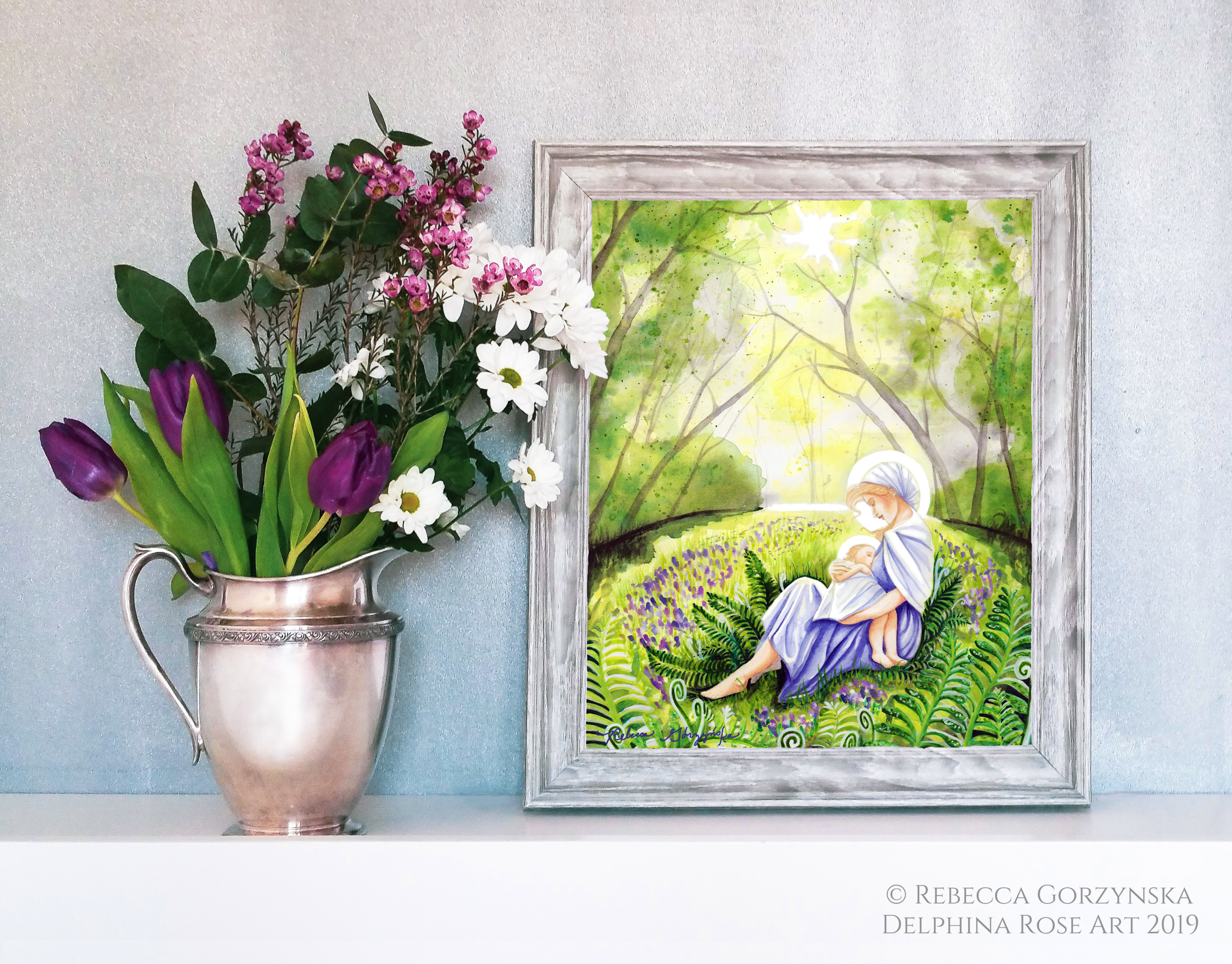 mother in blue dress nursing baby in green forest