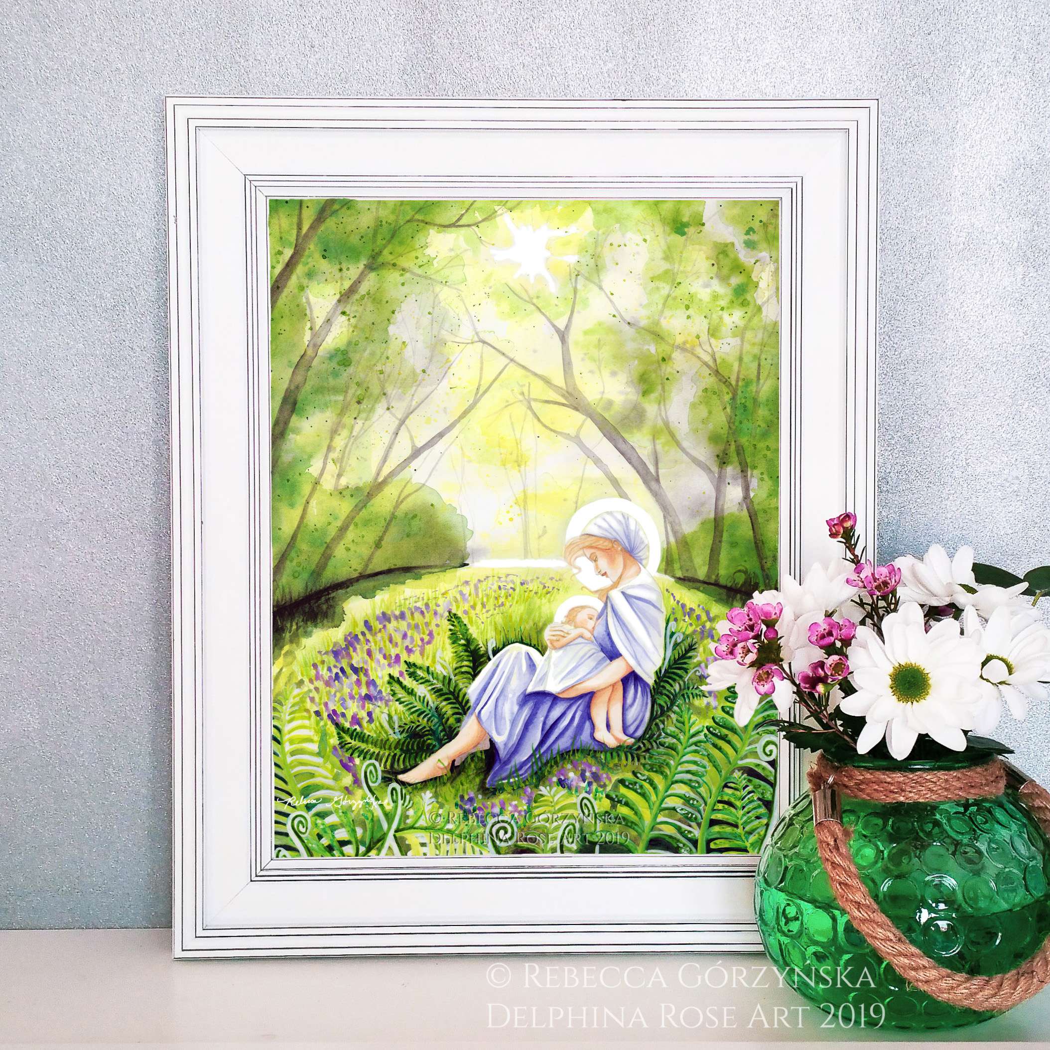 mother in blue dress nursing baby in green forest