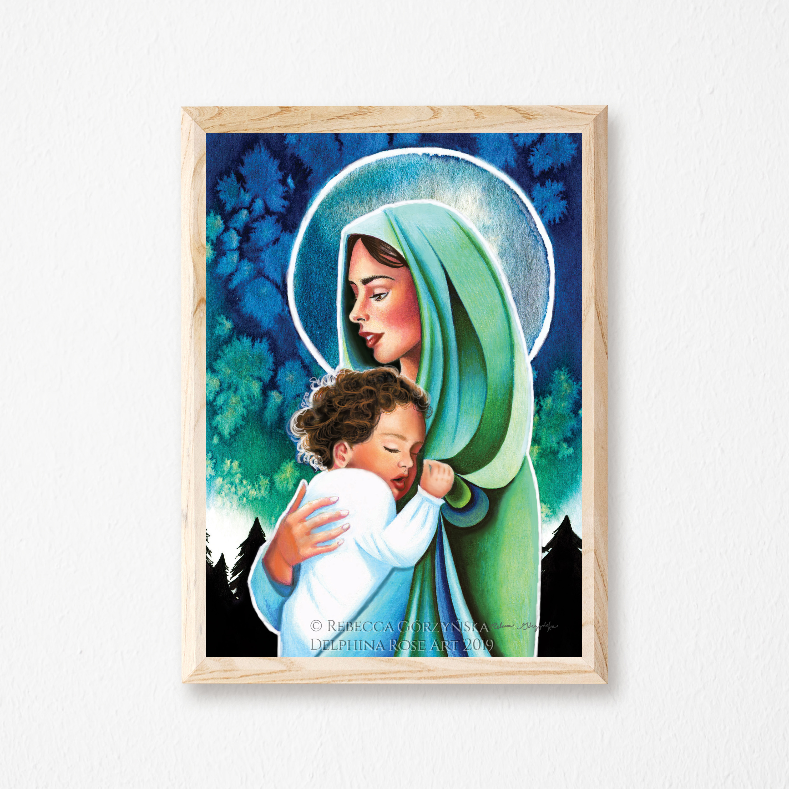 Mary wearing green veil holding sleeping toddler baby Jesus in front of a green-blue watercolor sky and black pine trees
